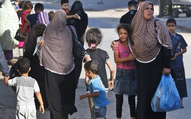 Menina chora enquanto palestinos fogem de suas casas no bairro de Shajaiyeh da Cidade de Gaza City depois de alerta de ataque de Israel (16/7)