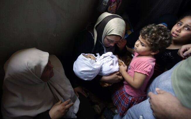 Mãe segura menina palestina de 4 anos que funcionários de hospital dizem que foi morta por ataque israelense em Jabaliya, norte da Faixa de Gaza (10/7)
