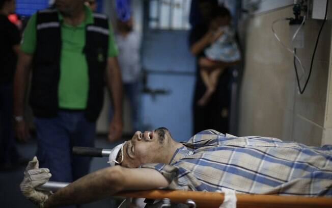 Palestino que, segundo os médicos, foi ferido após ataque israelense perto de mercado em Shejaia, aguarda atendimento em maca na Cidade de Gaza (30/07)