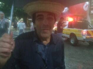 Ex-deputado Adriano Diogo Faria se protege da chuva durante ato da CUT