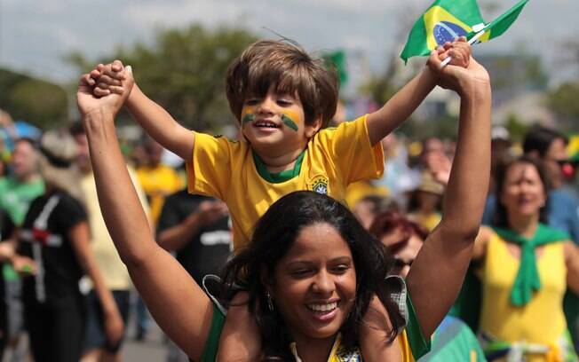 Mãe e filho participam de protesto vestido verde e amarelo em Brasília neste domingo dia 15 de março. Foto: AP Photo/Eraldo Peres