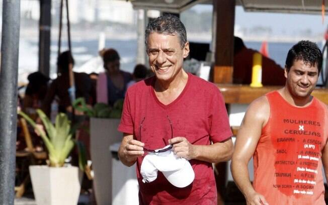 Chico Buarque sorri para fotógrafos após deixar praia e atender pedido de fãs