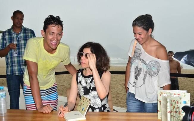 Fernanda Torres autografa livro em quiosque na praia em dia de chuva