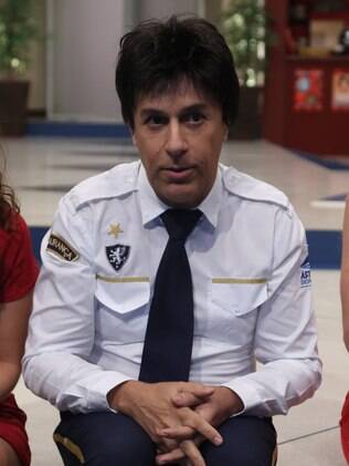 Tom Cavalcante como Gildo, o chefe de segurança do shopping aonde acontece a série