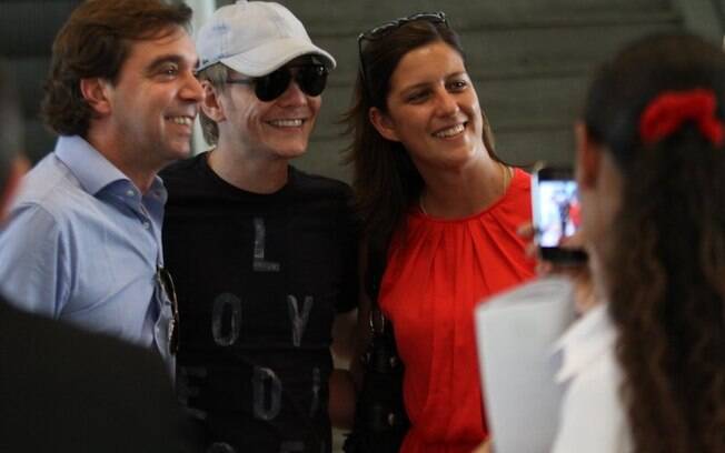 No aeroporto, Michel Teló sorri para a câmera de fãs antes de pegar seu voo  