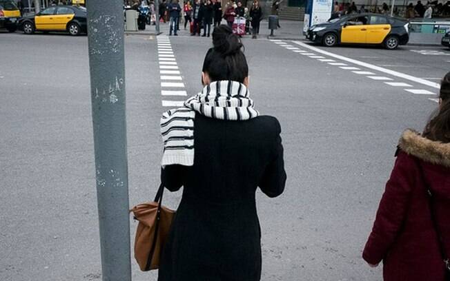Moça esperando pra atravessar a rua