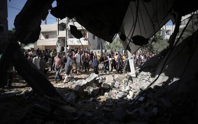 Palestinos olham casa destruída depois de ataque de míssil de Israel em Khan Younis, Faixa de Gaza (8/7)