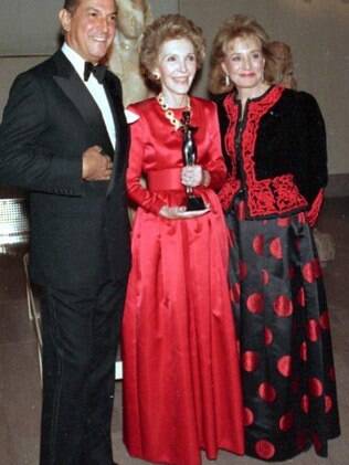 A primeira-dama Nancy Regan (de vermelho), em foto de 1989 com Oscar de la Renta, gostava de pegar roupas e joias emprestados