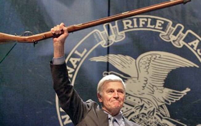 Na imagem de 2000, o ator Charlton Heston mostrou seu apoio ao armamento, ele inclusive liderou a 'National Rifle Association'