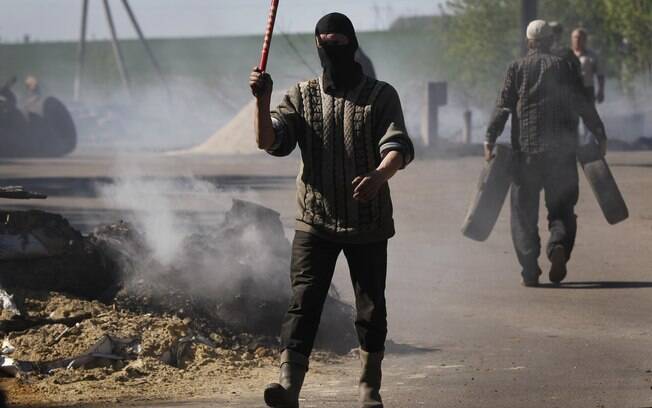 Militante mascarado pró-Rússia organiza o trânsito em posto de controle após ataque das tropas ucranianas em Slovyansk (24/4)