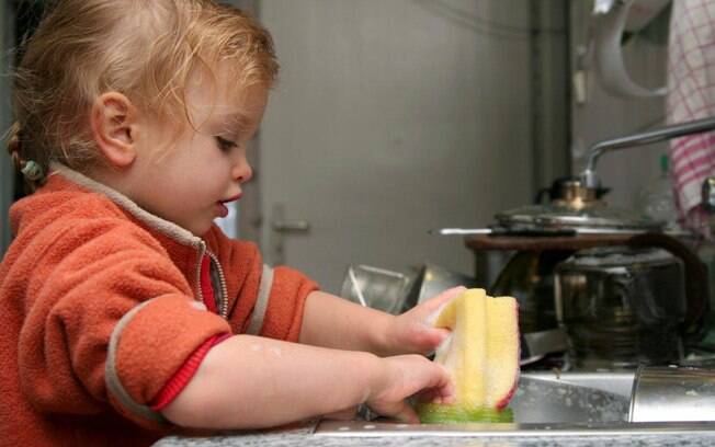 Chame seu filho para ajudar a lavar a louça depois das refeições. Ele pode colocar os itens menos delicados, como panelas, no escorredor. Foto: Thinkstock