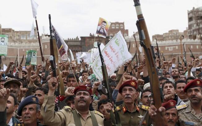 Rebeldes xiitas conhecidos como houthis levantam suas armas para protestar contra os ataques aéreos sauditas em Saana, Iêmen (26/03)