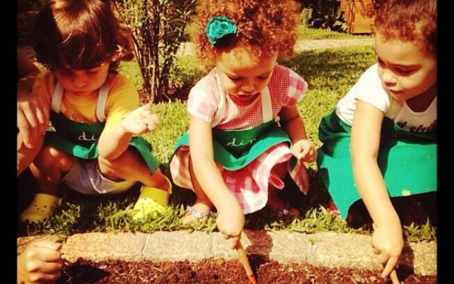 Maria Alice e Maria Sophia, filhas de Ronaldo e Bia Anthony, cuidam de jardim na companhia de uma amiguinha