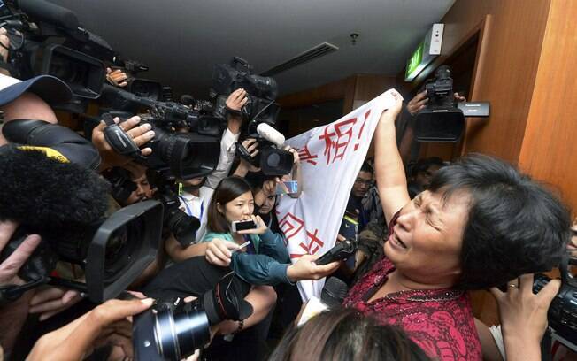 Parente de passageiros chineses do voo desaparecido chora em frente de jornalistas em hotel em Sepang, Malásia (19/3)