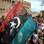 Líbios balançam a bandeira do país durante celebração em Trípoli. Foto: AFP