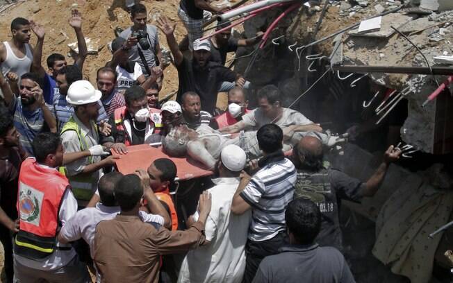 Equipe de resgate e civis palestinos removem corpo sem vida dos escombros de uma casa destruída por um míssil israelense na Cidade de Gaza (21/7)