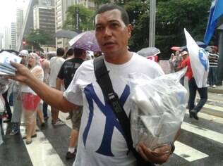 Manuel Marcos, de 50 anos, vende capas de chuva durante manifestação
