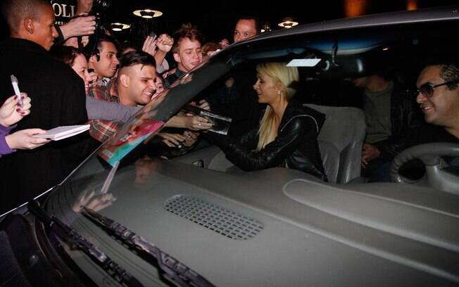 Em São Paulo, Paris Hilton abaixa o vidro do carro para distribuir autógrafos