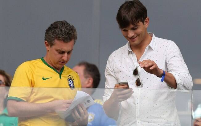 Ashton Kutcher optou por uma roupa neutra para assistir ao jogo do Brasil com Luciano Huck