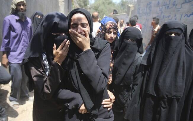Parentes de menina de 4 anos morta em ataque israelense choram durante enterro em Rafah, sul da Faixa de Gaza (15/7)