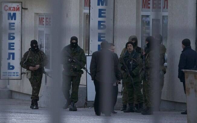 Homens armados não identificados caminham em área perto de unidade militar ucraniana em Simferopol, Crimeia (18/3)