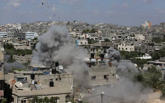 Fumaça e destroços sobem durante ataque 
aéreo de Israel contra prédio no campo de refugiados de Jabalya, norte da Faixa de Gaza (14/7)