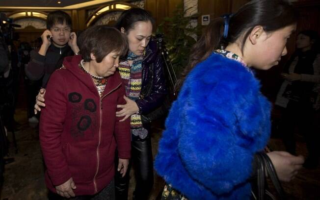 Parentes dos passageiros a bordo do voo desaparecido da Malaysia Airlines deixam sala de hotel após reunião com oficiais malaios, em Pequim, China (12/3). Foto: AP