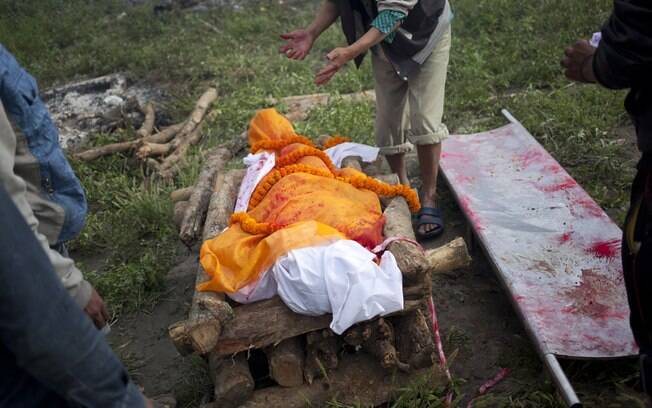 Homem executa ritos finais antes de cremar vítima do terremoto no Nepal