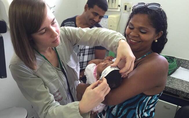 Técnicos do Centro de Controle de Doenças dos Estados Unidos examinam bebê com microcefalia