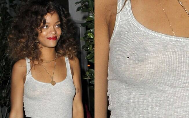 De calça preta e camiseta regata branca, Rihanna foi traida pelos flashes e deixou os seios à mostra
