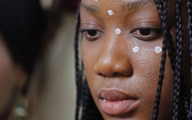 Aluna de uma escola sul-africana, com tradicionais manchas de tinta no rosto, participa de protesto silencioso pelas jovens raptadas na Nigéria (14/05). Foto: AP