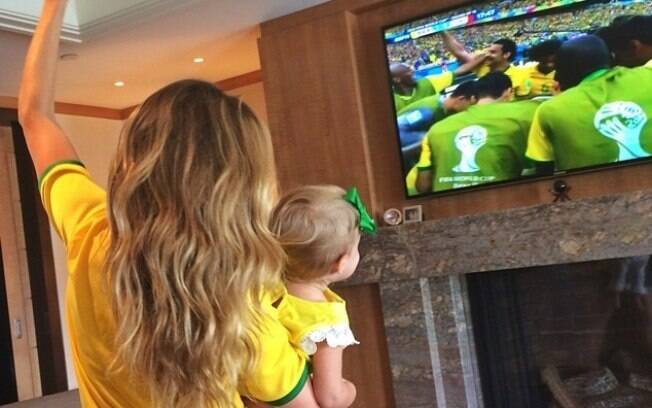 Gisele Bündchen comemora gol do Brasil com a filha no colo