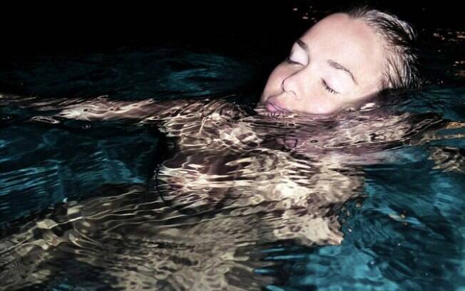 Modelo Lara Bingle publica foto nua na piscina