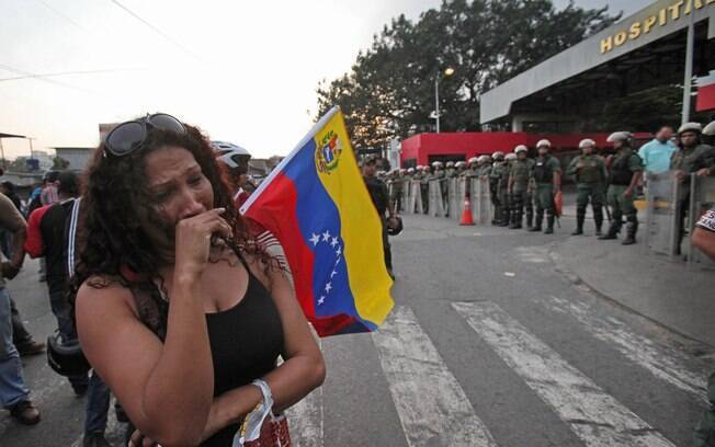 Mulher chora na frente do hospital militar em Caracas onde Hugo Chávez morreu (05/03)