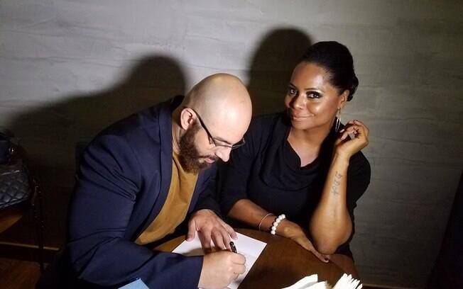 O jornalista e escritor Fabiano de Abreu autografa um exemplar de seu livro para Adriana Bombom