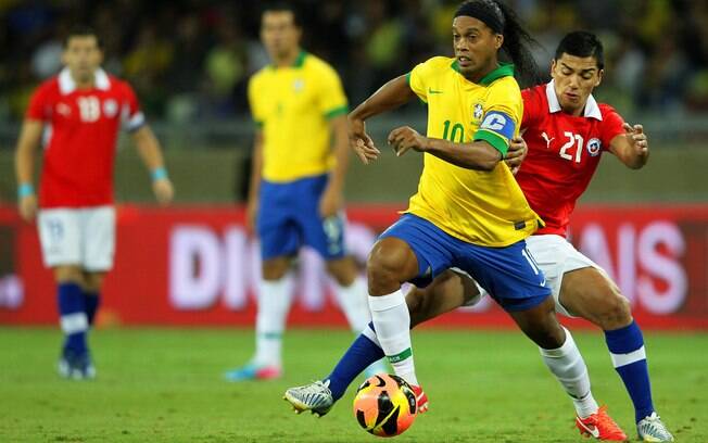 Ronaldinho protege a bola da marcação chilena