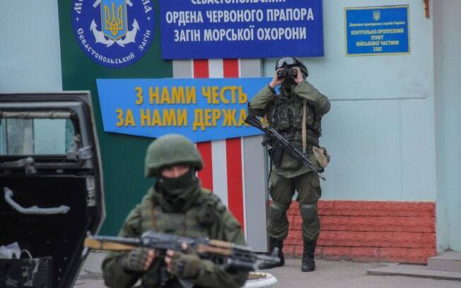 Soldados em uniformes sem identificação montam guarda durante tomada de controle de escritórios da Guarda Costeira em Balaklava, Crimeia, na Ucrânia (1/3)