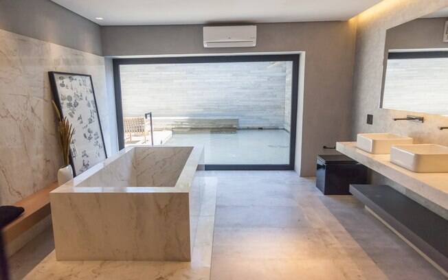 O espaço monocromático de 325 m² integra living, quarto, banheiro, cozinha e área externa com espelho d'água