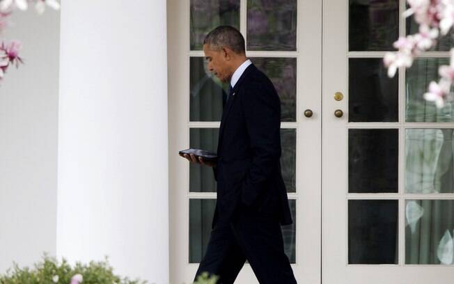 Presidente Barack Obama mexe no celular enquanto caminha rumo ao Salão Oval da Casa Branca em Washington, EUA (7/04)