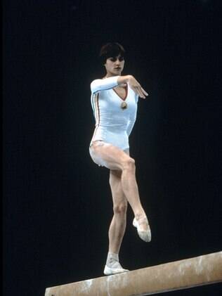 A legendária ginasta romena Nadia Comaneci se exercita na barra fixa nos Jogos de Moscou