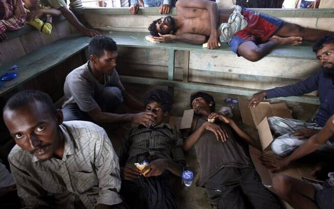 Migrantes recebem comida e bebida na chegada a Simpang Tiga, na província de Aceh, Indonésia
