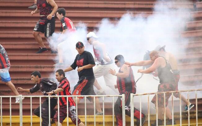 Torcedores do Atlético-PR correm para fugir da fumaça após briga com vascaínos