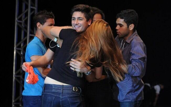 Daniel Rocha foi surpreendido por um grupo de fãs que subiu no palco onde o ator desfilava para agarrá-lo e beijá-lo