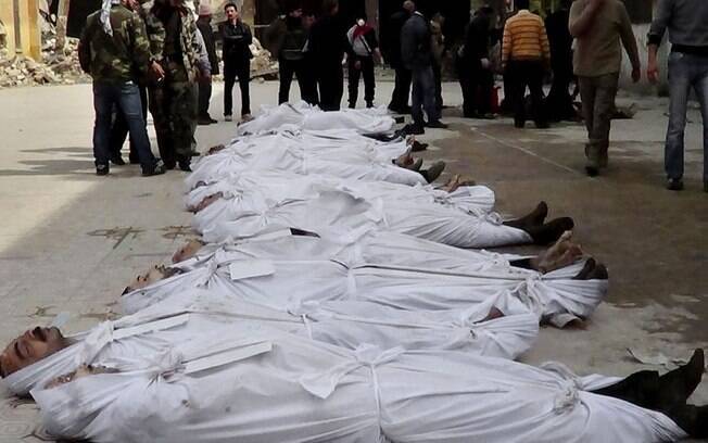 Sírias são vistos perto de corpos retirados de rio perto de bairro de Aleppo (10/03)