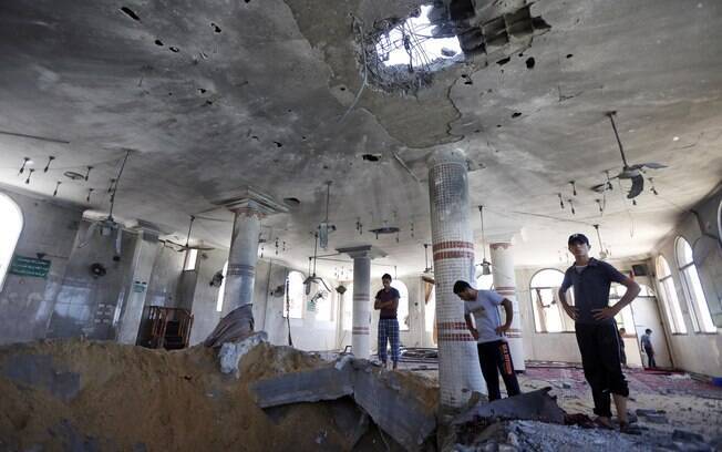 Palestinos verificam danos em mesquita 
atingida por ataque de Israel durante a madrugada na Faixa de Gaza (14/7)