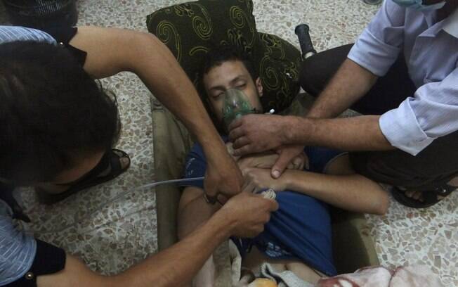Homem, afetado pelo que ativistas dizem ser gás neurológico, respira com ajuda de máscara de oxigêneo em subúrbio de Damasco