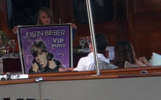 Lilly mostra ao pai o poster do cantor teen Justin Bieber, de quem é fã