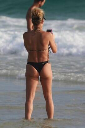 Famosa pela silhueta impecável, a atriz exibiu uma barriguinha fora do comum em dia de praia com os filhos. Foto: AgNews