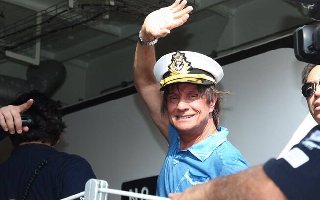 Roberto Carlos acenou aos paparazzi antes de entrar no navio