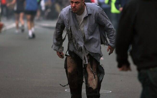 Homem caminha com as calças rasgadas após explosões na Maratona de Boston (15/04)